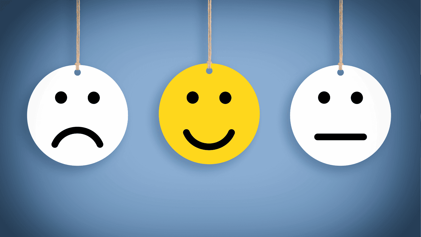 Three round faces hang on strings: one white with a sad face, one yellow with a happy face, and one white with a neutral face, all on a blue gradient background.