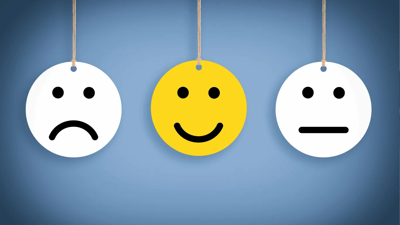 Three round faces hang on strings: one white with a sad face, one yellow with a happy face, and one white with a neutral face, all on a blue gradient background.